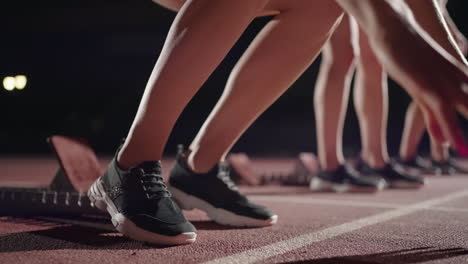 Close-up-camera-follows-the-feet-of-runners-in-sneakers-in-the-dark-with-backlight-matching-the-running-shoes